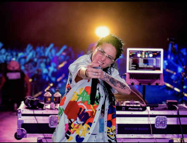 One of our female DJs for parties posing and pointing to camera and audience cheers in excitement behind her | Altus Entertainment